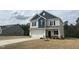 Two story home featuring blue and grey siding, attached two-car garage and minimal landscaping at 165 Knoll Way, Sanford, NC 27332