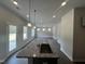 Kitchen island featuring granite countertops, pendant lighting, and wood-look floors at 165 Knoll Way, Sanford, NC 27332