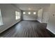 Bright living room with wood-look floors, three windows and neutral wall color at 165 Knoll Way, Sanford, NC 27332