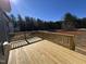 Unstained wooden deck overlooks the property's partially cleared backyard with a wooded area in the distance at 200 Ironwood Lot 39 Blvd, Youngsville, NC 27596