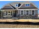 Charming two-story home featuring stone accents, covered porch, and multiple windows at 200 Ironwood Lot 39 Blvd, Youngsville, NC 27596