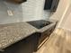 Close-up of a granite countertop with electric cooktop and dark cabinets at 200 Ironwood Lot 39 Blvd, Youngsville, NC 27596