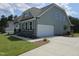 Side exterior view featuring a two-car garage and well maintained lawn at 200 Ironwood Lot 39 Blvd, Youngsville, NC 27596