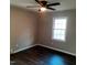 A cozy bedroom featuring neutral walls, dark hardwood floors, and a ceiling fan with an overhead light at 2800 Coleman Loop Rd, Hillsborough, NC 27278