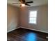 A cozy bedroom featuring neutral walls, dark hardwood floors, and a ceiling fan with an overhead light at 2800 Coleman Loop Rd, Hillsborough, NC 27278