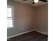 A cozy bedroom featuring neutral walls, dark hardwood floors, a ceiling fan with light, and one window at 2800 Coleman Loop Rd, Hillsborough, NC 27278