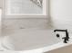 Elegant soaking tub in the bathroom with a large window that provides natural light at 906 Brookfield Dr, Gibsonville, NC 27249