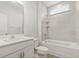 Bright bathroom features a shower-tub combo with white fixtures, tiled walls, and hardwood floors at 906 Brookfield Dr, Gibsonville, NC 27249