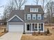 Two-story home features a two-car garage, covered front porch, and tasteful blue and gray exterior at 906 Brookfield Dr, Gibsonville, NC 27249