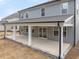 Back exterior of two-story home featuring covered patio, gray siding, and manicured yard at 906 Brookfield Dr, Gibsonville, NC 27249