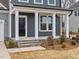 A close-up of the front porch shows stone steps and white pillars at 906 Brookfield Dr, Gibsonville, NC 27249