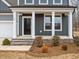 Close up of the front porch with white pillars and a solid black front door at 906 Brookfield Dr, Gibsonville, NC 27249