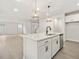 Open concept kitchen with island, white cabinets, stainless appliances, stone countertops, and hardwood floors at 906 Brookfield Dr, Gibsonville, NC 27249