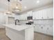 This kitchen features white cabinets, stainless steel appliances, a large island, and a hardwood floor at 906 Brookfield Dr, Gibsonville, NC 27249