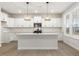 Bright kitchen features white cabinets, stainless steel appliances, large island, and decorative pendant lighting at 906 Brookfield Dr, Gibsonville, NC 27249