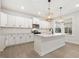 Bright kitchen features white cabinets, stainless steel appliances, large island, and decorative pendant lighting at 906 Brookfield Dr, Gibsonville, NC 27249