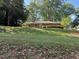 Charming red brick home with a well-manicured lawn and mature trees, nestled on a sunny, grassy knoll at 2705 Royster St, Raleigh, NC 27608