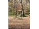 Quaint wooden gazebo with a picnic table surrounded by a leaf-covered ground in a wooded area at 2705 Royster St, Raleigh, NC 27608