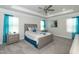 A stylish bedroom with a tray ceiling, a ceiling fan, large windows, and a well-decorated bed at 596 Ravensworth Dr, Garner, NC 27529