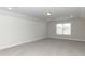 This bonus room features gray carpet, a window, and recessed lighting at 596 Ravensworth Dr, Garner, NC 27529