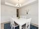 A bright dining room with white furniture, wainscoting on the walls, and a decorative chandelier at 596 Ravensworth Dr, Garner, NC 27529