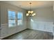 Bright dining room features hardwood floors, wainscoting, and a chandelier at 828 Putney Hill Rd, Zebulon, NC 27597