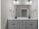Bathroom featuring double sinks, white cabinets, modern faucets, and spacious mirror at 125 Leisure Ln, Louisburg, NC 27549