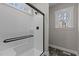 Walk-in shower featuring modern fixtures, black trim, window, and stylish tile flooring at 125 Leisure Ln, Louisburg, NC 27549