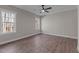 Bright bedroom featuring wood floors, ceiling fan, and natural light from two windows at 125 Leisure Ln, Louisburg, NC 27549