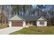 Inviting single-story home with stone details, attached garage, and well-maintained front lawn at 125 Leisure Ln, Louisburg, NC 27549