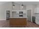 Bright kitchen boasts stainless appliances, stylish fixtures, wood floors, and spacious island at 125 Leisure Ln, Louisburg, NC 27549