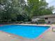 Community swimming pool with lounge chairs and umbrella-covered tables at 130 S Estes Dr # G5, Chapel Hill, NC 27514