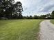 Spacious yard with plenty of room, showcasing the property's natural surroundings and gravel driveway at 2253 Nc Highway 96 S, Franklinton, NC 27525