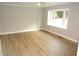 An empty bedroom features sleek wood flooring, white trim, and a large window at 2253 Nc Highway 96 S, Franklinton, NC 27525