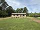 One-story home with a well-manicured lawn and landscaping, set against a backdrop of mature trees at 2253 Nc Highway 96 S, Franklinton, NC 27525
