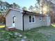 Side view of a ranch house with gray siding and a grassy yard at 2253 Nc Highway 96 S, Franklinton, NC 27525