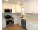 Modern kitchen with white cabinets, stainless steel appliances and a teal dishwasher at 2253 Nc Highway 96 S, Franklinton, NC 27525