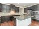 Modern kitchen featuring dark cabinetry, granite island, and stainless steel appliances at 226 Begen St, Morrisville, NC 27560