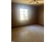 Bedroom featuring wood paneling, vintage flooring, and natural light from a large window at 420 E Hinton St, Clayton, NC 27520