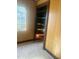 Room featuring wood paneling, vintage flooring, a window, and built-in shelving at 420 E Hinton St, Clayton, NC 27520