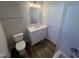 Clean bathroom featuring a white vanity with a solid surface top, modern fixtures, and wood-look flooring at 4553 Dedication Dr, Raleigh, NC 27610