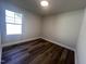 This bedroom features durable wood-look floors, a large window and neutral paint at 4553 Dedication Dr, Raleigh, NC 27610