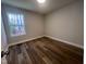 Bedroom with wood-look flooring, neutral walls, and a bright window at 4553 Dedication Dr, Raleigh, NC 27610