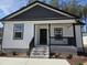 Inviting front porch with black railing and brick-lined steps, offering a welcoming entrance at 4553 Dedication Dr, Raleigh, NC 27610