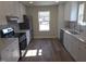 Bright kitchen featuring white cabinets, stainless steel appliances, and a view from the window at 4553 Dedication Dr, Raleigh, NC 27610