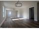 Spacious living room with wood floors, fan, and abundant natural light from large windows at 4553 Dedication Dr, Raleigh, NC 27610