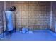 Utility room featuring a water tank, paint cans, and wood paneling at 4553 Dedication Dr, Raleigh, NC 27610