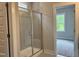 Tiled walk-in shower in bathroom with glass enclosure and a view into the light and bright bedroom space at 105 Windchime Ct, Fuquay Varina, NC 27526