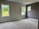 Carpeted bedroom with natural light from multiple windows with views of outside trees and greenery at 105 Windchime Ct, Fuquay Varina, NC 27526
