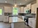 Modern kitchen featuring white cabinetry, quartz countertops, stainless steel appliances, and kitchen island at 105 Windchime Ct, Fuquay Varina, NC 27526
